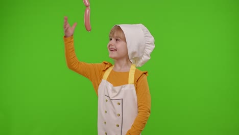 Child-girl-kid-dressed-as-cook-chef-taking-sausages-from-above,-fooling-around,-making-faces