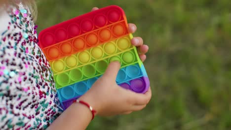 Niña-Jugando-Coloridas-Burbujas-De-Silicona-Blandas-Juguete-Sensorial-Simple-Hoyuelo-Pop-It-Juego,-Primer-Plano