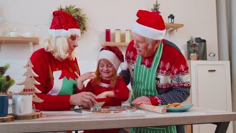Funny-senior-grandparents-and-granddaughter-playing-with-flour-smearing-on-face-at-Christmas-kitchen