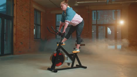 Sportliche-Frau,-Die-Auf-Einem-Stationären-Spinning-Fahrrad-Trainiert,-Im-Fitnessstudio-Trainiert,-Gewichtsverlust-Im-Innenbereich