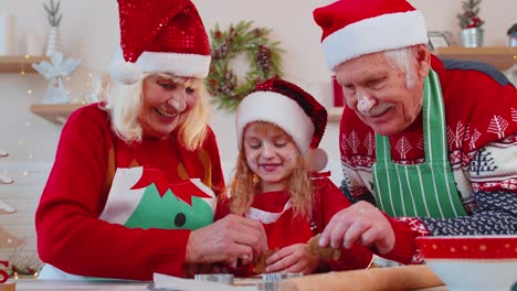 Senior-family-grandmother,-grandfather,-granddaughter-preparing,-cooking-homemade-Christmas-cookie