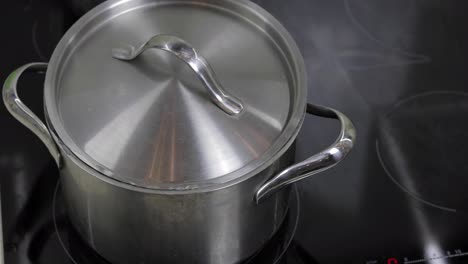 Boiling-Water-In-The-Pan-that-is-covered-with-a-lid-in-the-kitchen