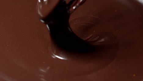 Slow-motion-mixing,-stirring-premium-dark-melted-chocolate-with-a-whisk,-process-of-making-sweets