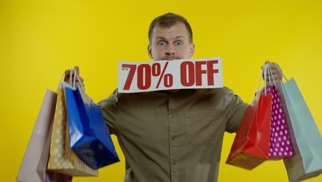 Surprised-man-showing-shopping-bags-and-Up-To-70-percent-Off-inscription-in-his-mouth.-Black-Friday