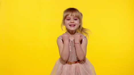 Hello-or-bye.-Little-smiling-blonde-child-kid-girl-waving-greeting-with-hand-on-yellow-background
