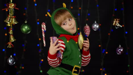 Kid-girl-in-Christmas-elf-Santa-Claus-helper-costume-making-selfie-on-smartphone.-New-Year-holidays