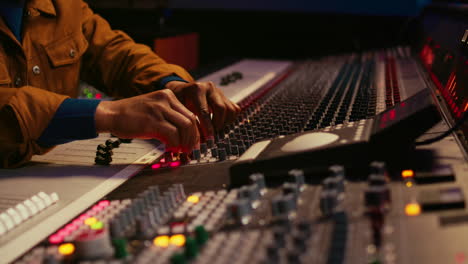 African-american-producer-uses-control-desk-with-automatic-equalizer