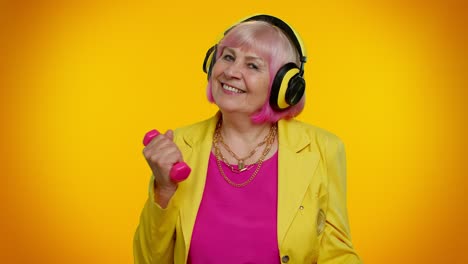 Senior-granny-woman-listening-music-via-headphones,-working-out,-lifting-pink-dumbbells,-healthcare