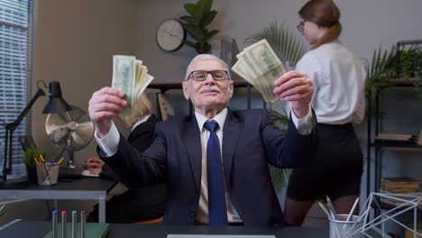 Cheerful-senior-business-company-manager-celebrating-business-success-dancing-with-money-dollar-cash