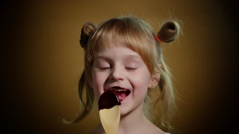 Niña-Feliz-Lamiendo-Chocolate-Derretido,-Niño-Comiendo,-Disfrutando-De-Comida-Dulce-Poco-Saludable-En-El-Interior
