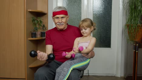 Active-grandfather-senior-man-with-child-girl-doing-fitness-weight-lifting-exercises-with-dumbbells