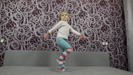 Un-Niño-Feliz-Saltando-Y-Bailando-En-El-Sofá-Y-Escuchando-Música.