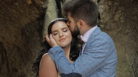 Groom-with-bride-standing-in-cave-of-mountain-hills.-Wedding-couple-in-love