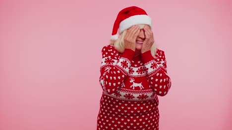 Frau-Im-Pullover-Weihnachtsmann-Weihnachtsmütze-Herumalbern-Mit-Geschlossenen-Augen-Mit-Der-Hand-Und-Spionage-Durch