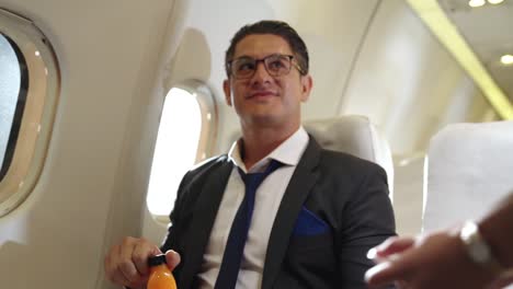 Businessman-have-orange-juice-served-by-an-air-hostess-in-airplane