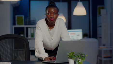 Afrikanische-Geschäftsfrau-Steht-Am-Schreibtisch-Und-Blickt-In-Die-Kamera