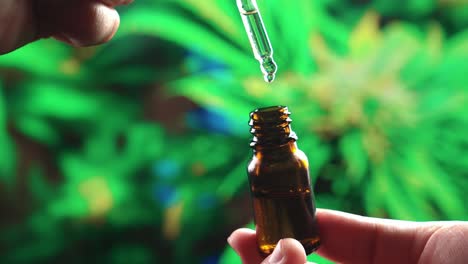 Closeup-hand-holding-medical-CBD-oil-bottle-from-legalized-cannabis-hemp-leaf.