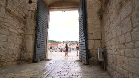 Tourist-walks-on-street-of-Trogir,-Croatia