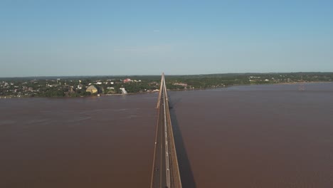 Aerial-flyover-bridge-with-traffic-crossing-border-of-Paraguay-and-Argentina-during-sunny-day
