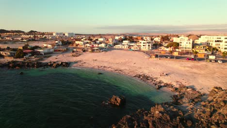 Luftbild-Dolly-Am-Strand-Von-Bahia-Inglesa-In-Der-Coquimbo-Region-Mit-Orangefarbenen-Farben-Und-Kristallklarem-Wasser-Bei-Sonnenuntergang