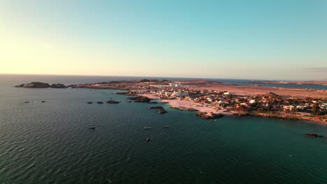 Panoramic-aerial-view-descending-over-the-Bahía-Inglesa-at-sunset,-Coquimbo-region,-Chile