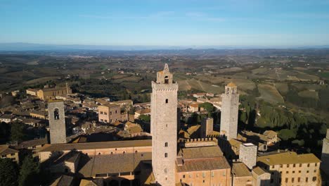 Backwards-Drone-Shot-Reveals-Epic-Medieval-Towers-in-San-Gimignano,-Italy