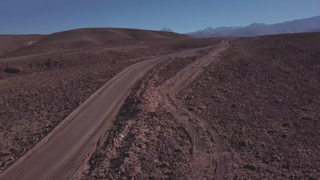 A-dusty-road-in-the-Atacama-Desert-with-an-arid-landscape-in-Northern-Chile
