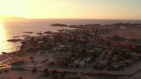 Bird's-eye-view-of-the-beach-town-of-Bahia-Inglesa-in-the-Coquimbo-region-with-the-sunset-in-the-background,-Chile