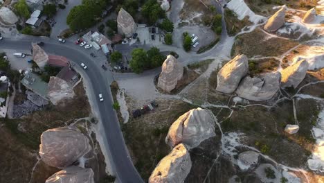 Aerial-view-of-cars-driving-on-paved-street-in-old-shaped-beautiful-Cappadocia-City-in-Turkey