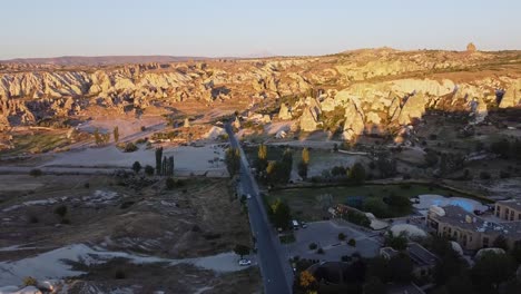 -Aerial-view-of-paved-access-road-with-cars-to-rocky-formations-of-Cappadocia-City-in-Turkey