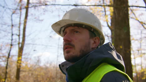 Slow-motion-closeup,-workman-in-protective-clothing-observing-woodland