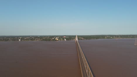 Aerial-orbit-shot-of-Santa-Cruz-Bridge-over-Rio-Parana-River-during-Sunny-day-with-blue-sky