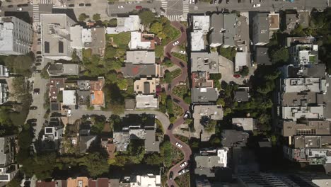 Aufnahme-Der-San-Francisco-Residenzen-Mit-Einer-Drohne,-Mit-Luft--Und-Filmaufnahmen,-Die-Eine-Kurvenreiche-Straße-Durch-Die-Mitte-Hervorheben,-Mit-Fahrenden-Fahrzeugen