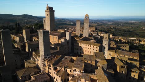 Drone-Flies-Past-Medieval-Towers-in-San-Gimignano,-Siena,-Tuscany,-Italy