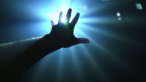Hand-reaching-out-to-cover-shinning-spot-light