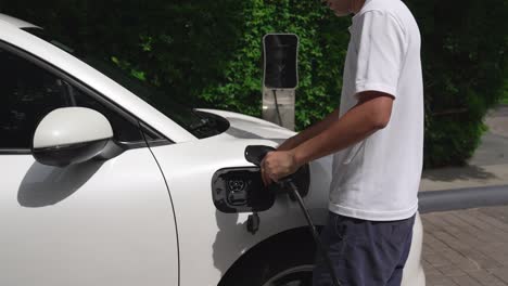 Progressive-man-install-cable-plug-to-his-EV-car-from-home-charging-station.