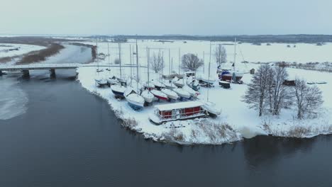In-winter,-the-yachts-stand-on-the-shore-and-are-covered-with-a-thick-layer-of-snow