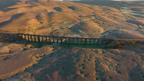 Railway-bridge-viaduct-spanning-English-moorland-at-sunrise-in-winter