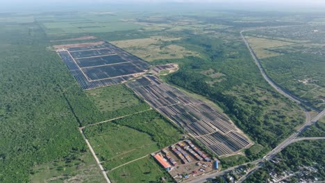 Aerial-view-of-solar-panels-surrounded-by-green-vegetated-fields-during-sunny-day-in-La-Romana
