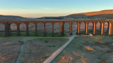 Railway-bridge-with-many-arches-catching-dawn-light-spanning-desolate-moorland