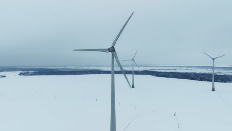 Aerial-view-Three-wind-turbines-rotate-during-the-winter-and-produce-green-energy-for-consumers