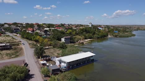 Zipline-drone-shot-of-a-quiet-fishing-village-in-by-the-Danube-River-Delta,-located-in-Tulcea-County,-in-Northern-Dobruja,-in-Romania