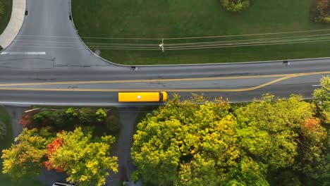 Yellow-school-bus-driving-on-suburban-American-street