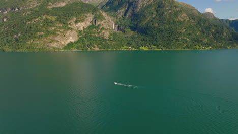 Drohne-Umkreist-Schnellboot,-Das-Wasserskifahrer-Im-Lustra-Fjord-In-Norwegen-Zieht