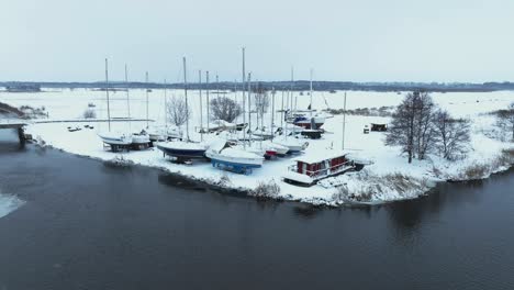 Aerial-view-In-winter,-the-yachts-stand-on-the-shore-and-are-covered-with-a-thick-layer-of-snow