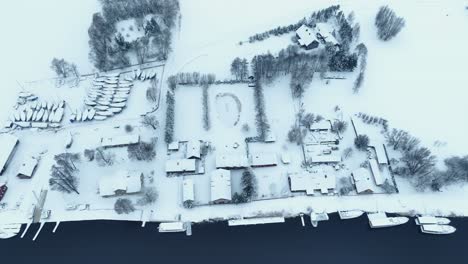 Aerial-view-northern-bank-of-the-village-by-the-river-in-winter