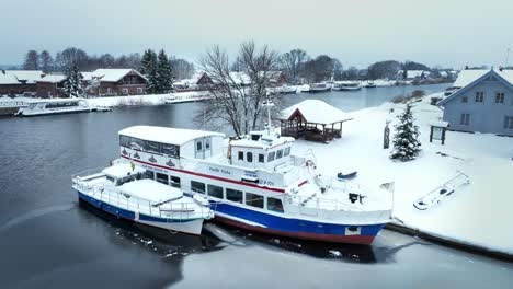 Two-pleasure-boats-are-moored-at-the-quays-in-the-river-in-winter