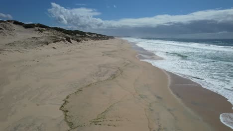 Fliegen-über-Einem-Langen-Sandstrand-Mit-Schaumigen-Wellen-Am-Mungo-Beach-In-New-South-Wales,-Australien