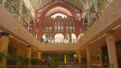 Christmas-Decor-Inside-The-Market-Building-With-Shoppers-At-Mercado-de-Colón-In-Valencia,-Spain