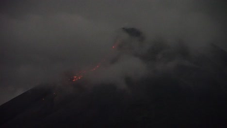 view-of-the-incandescent-of-the-peak-of-Mount-Merapi-in-Yogyakarta,-Indonesia,-accompanied-by-thick,-dense-fog-covering-it